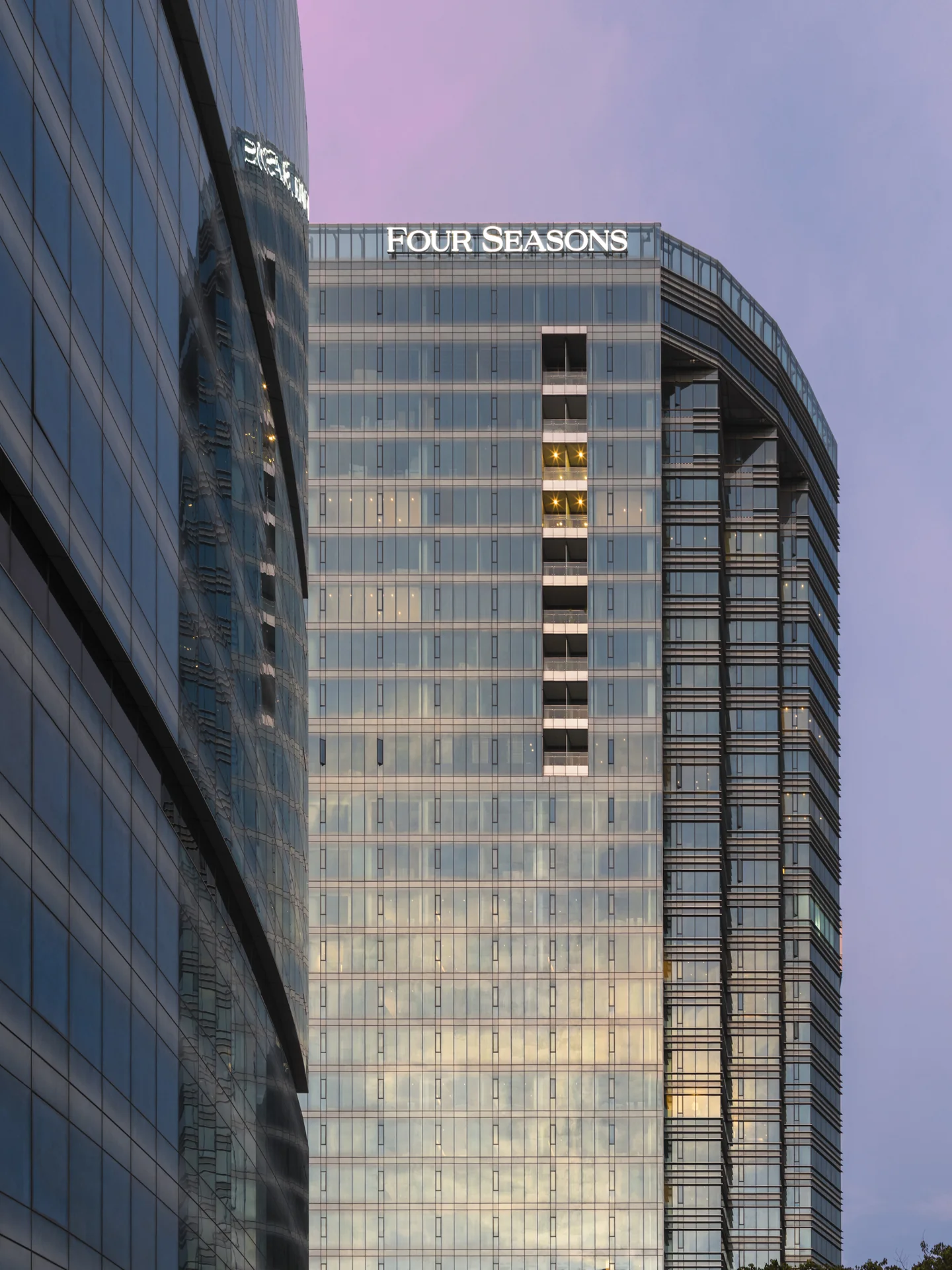 Glass facade of Four Seasons Hotel Bengaluru at Embassy ONE at dusk