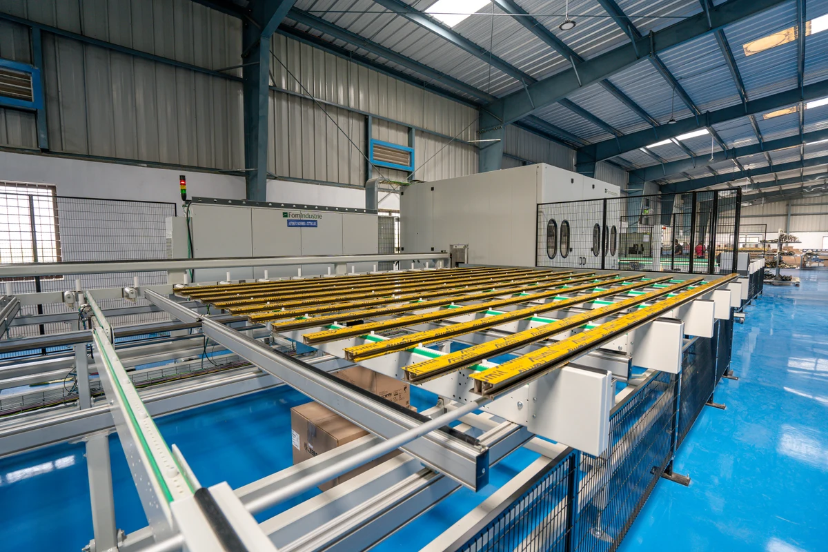 Enclosed fabrication equipment with profile feed tables and protective fencing